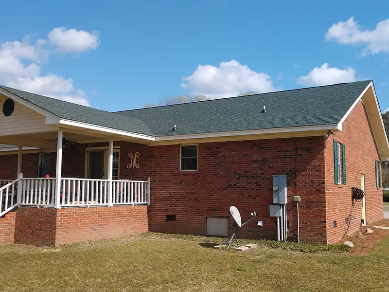 Mid-class, brick home with a new dark gray shingle roof